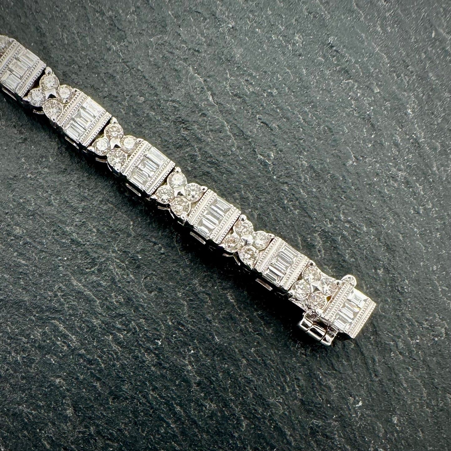 Pre-Owned: Precious white metal round brilliant & emerald cut diamond set bracelet. 4.01ct.