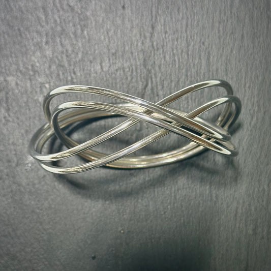 Pre-Owned: One George Jensen sterling silver intertwined bangle.