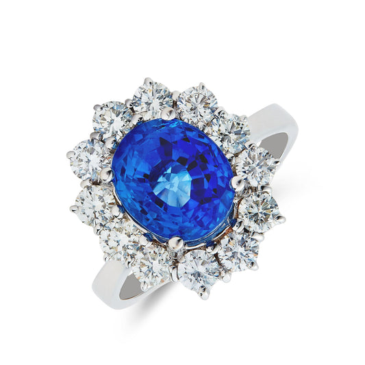 18ct white gold & oval cut sapphire ring surround of round brilliant cut diamond cluster.