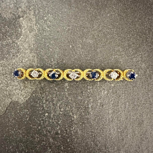 Pre-Owned One 18ct gold sapphire and diamond set textured bar brooch.