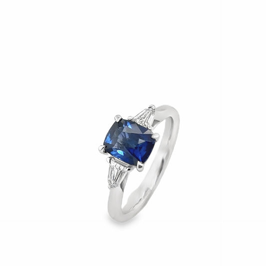 Platinum cushion shaped sapphire & bullet cut diamond three stone ring.